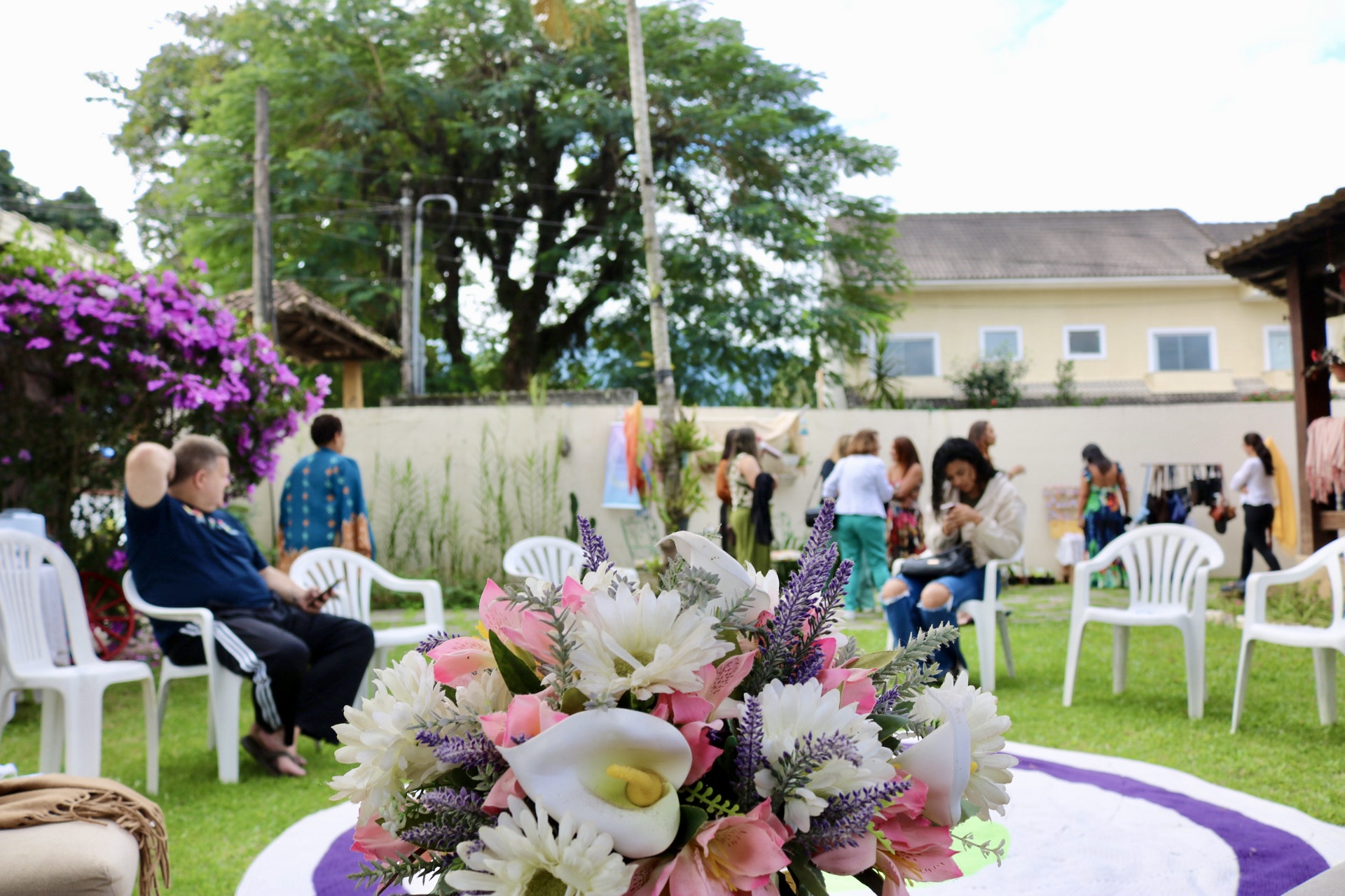 Ambiente da vivência ao ar livre, com flores e cadeiras em círculo